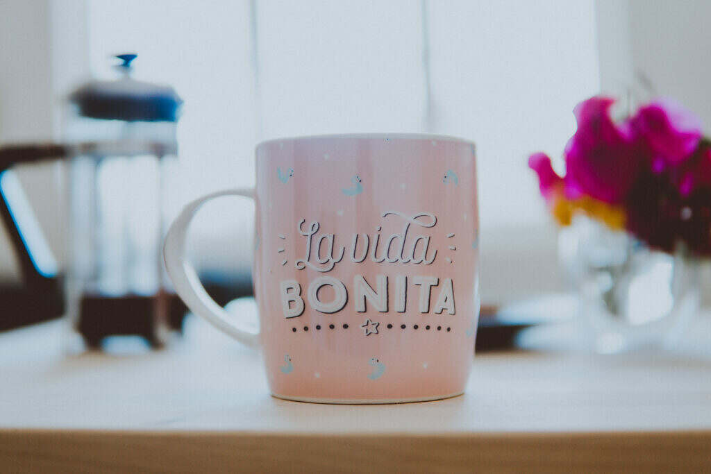 Pink and white ceramic mug on brown wooden table